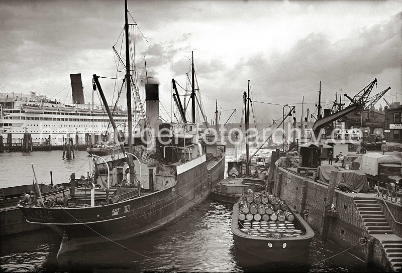 Historisches Hafenbild aus Hamburg / Motorschiff am Johannisbollwerk / Vorsetzen - Schute mit Fssern beladen, Passagierschiff; ca. 1937.  536_B_231 Das Motorschiff KTHE aus Kiel liegt beim Kai beim Johannisbollwerk / Vorsetzen. An der Kaimauer hat eine Schute beladen mit Fssern fest gemacht - eine Treppe fhrt zum Wasser. Im Hintergrund liegt ein Passagierdampfer am Ponton.