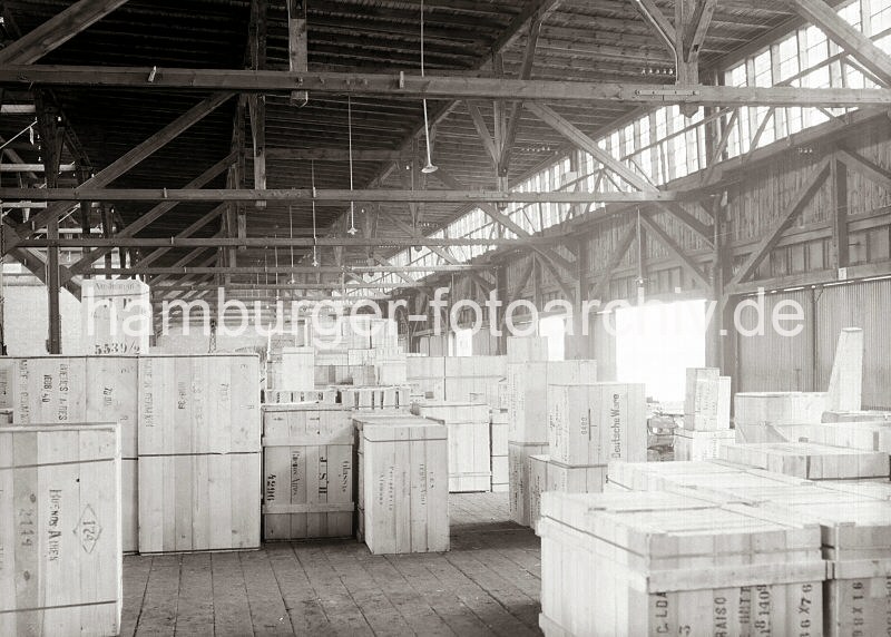 Historische Hafenbilder aus dem Fotoarchiv der HHLA. Lagerschuppen am Kamerunkai - Kisten fr den Export nach Buenos Aires / Argentinien. Historische Hamburgfotos als Weihnachtsgeschenk. 592_666 Im Kaischuppen des Kamerunkais sind die Kisten fr den Export nach Bestimmungsort gestapelt. Die Aufdrucke auf den Holzkisten weisen z.B. auf deren Inhalt wie z. B. "Glass", den Zielort der Fracht "Buenos Aires" und das Ursprungsland der Ware "Made in Germany" hin.