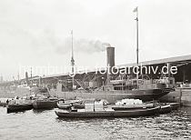 604_597 Der Frachter GANNET mit Heimathafen London liegt im Grasbrookhafen am Dalmannkai und wird be- und entladen. Mehrere beladene Schuten haben am Schiff fest gemacht. Am Bordkran des Frachters hngt eine Ladung Kisten. Ganz lks. im Hintergrund der Turm des Kaiserspeichers.