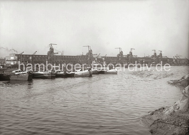 Historische Hafenbilder aus dem Fotoarchiv der Hamburger Hafen und Logistik AG, HHLA. Kaianlage des Kamerunkai - Schuten im Hamburger Sd-West-Hafens.  618_639a Der alte Petroleumhafen wurde ab der 1920er Jahre zum Sdwesthafen umgebaut; Schuten liegen in der Mitte des Hafenbeckens. Im Hintergrund liegen die langgestreckten Kaischuppen 60/61/62 am Kamerunkai. Rechts ist das noch unbefestigte Ufer des Togokais zu erkennen.