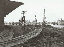 621_03502_58 Der alte Petroleumhafen wurde ab der 1920er Jahre zum Sdwesthafen umgebaut. Die Kaianlage des zuknftigen Togokais ist noch eine Baustelle. Provisorische Schienen sind auf Holzgersten verlegt - auf ihnen transportieren Bauloren Schutt und Material. Rechts liegen ein Frachtschiff am Kamerunkai und im Hintergrund ist das tonnengewlbte Dach des Schuppens 59 am Windhukkai zu erkennen.