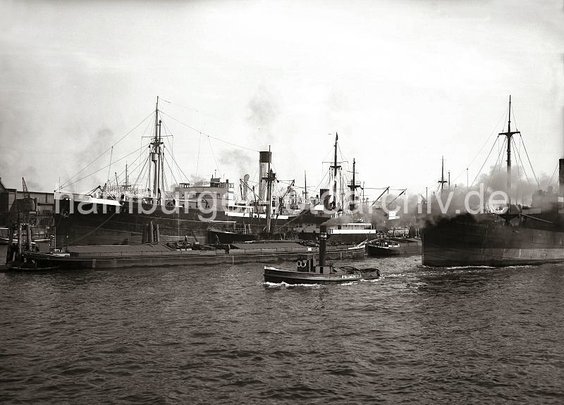 Alte Hafenmotive aus Hamburg. Blick vom Afrikahft auf den Indiahafen + Hansahafen - Frachtschiff Clara Blumenfeld; ca. 1934.  622_30_B_132 Blick vom Afrikahft auf den Indiahafen; der nach der Tochter des Reeders benannte Frachter "Clara Blumenfeld" wird von einem Schlepper der Reederei Bd.Blumenfeld unter dickem Qualm aus dem Indiahafen geschleppt. An den Dalben liegen zwei Binnenschiffe, das Motorschiff AMBRIA und der Frachter TENERIFE.