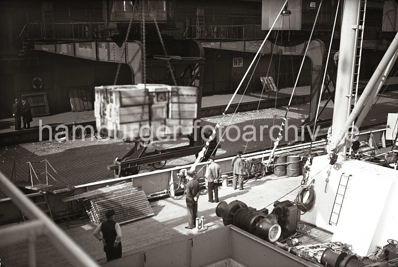 Historische Hafenmotive aus dem Archiv der Hamburger Hafen und Logistik AG  HHLA. Beladung eine Frachters im Indiahafens - Kisten im Ladegeschirr des Hafenkrans; ca. 1936.  625_B_248a Blick ber das Deck eines im Indiahafen liegenden Frachters. Eine Ladung Kisten schwebt ber dem Laderaum des Frachtschiffs - im Hintergrund die Laderampe des Kaischuppens.