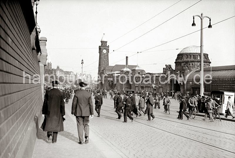 Historische Hamburgbilder aus dem Archiv der HHLA. Feierabend im Hamburger Hafen - Hafenarbeiter an den St. Pauli Landungsbrcken; ca. 1934.  642_397a Kurz nach 17.00 Uhr strmen Hamburger Hafenarbeiter ber den Vorplatz der St. Pauli Landungsbrcken - sie kommen von den Hafenfhren oder aus dem St. Pauli Elbtunnel. Einige fahren mit dem Fahrrad ber das Kopfsteinpflaster; im Hintergrund stehen Straenbahnen an der Haltestelle Landungsbrcken.