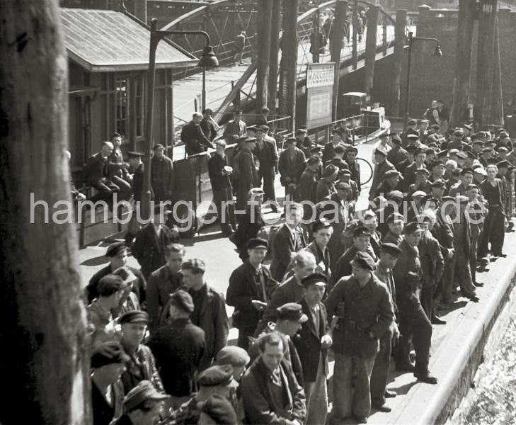 Historische  Bildmaterial von der Arbeit im Hamburger Hafen aus dem Archiv der HHLA. Feierabend am Rokai - Hafenarbeiter warten am Anleger auf die Hafenfhre; ca. 1948.  645_2 Fhranleger am Rohft, der ueren Spitze des Rohafens und Ellerholzhafens. Die Hafenarbeiter haben Feierabend und warten am Ponton auf eine der Hafenfhren, die nach Fahrplan ihre regelmigen Rundfahrten zu den einzelnen Anlegern im Hamburger Hafen machen.