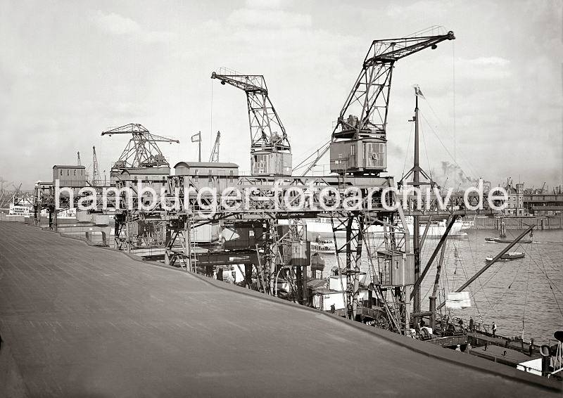 648_541a Blick vom Dach des Schuppen 83 im Oderhafens auf die Arbeit der Dreifachkrne am Chilekai. Neben dem Drehkran mit Wippausleger, der Lasten bis zu 3 Tonnen bewegen kann, kann die Krananlage zwei Laufkatzen am eigenen Ausleger mit je 3 Tonnen bewegen. Historische  Bilddokumente der Hafenarbeit im Hamburger Hafen. Dreifachkrne am Chilekai des Oderhafens - Drehkran mit Wippausleger; ca. 1934. 