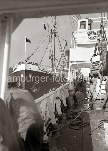 Historische  Fotodokumente vom berseehafen Hamburg. Schiffsdeck im Hamburger Hafen; ca. 1934 656_683 Blick auf das Deck eines Frachter im Hamburger Hansahafen. Ein Motorschiff mit Hamburger Wappen am Bug hat lngsseits fest gemacht.