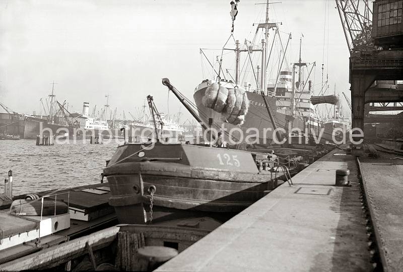Bilddokumente zur Geschichte des Hamburger Hafens - historische Fotos Schiffe am Hafenkai - Gterumschlag; ca. 1934.  662_345a Am Kai liegen mehrere Frachter, Schuten und ein Binnenschiff - zwei Baumwollballen hngen am Kranhaken des Halbportalkrans.