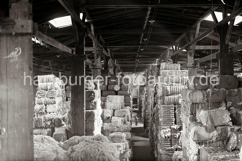 Lagerhaus C am Melniker Ufer - Hamburger Moldauhafen, Lagerung von Wollballen - Fotodokumente der Hamburger Hafen und Logistik AG HHLA zur Geschichte des Hafens.  681_372a Im Lagerhaus C des Melniker Ufers im Hamburger Moldauhafen sind mit Bandeisen verschnrte Wollballen bis unter die Decke des Speichers gelagert. Licht fllt ber die Oberlichter auf die Gter - fr den Nachtbetrieb hngen Lampen an der Decke ber dem Gang.