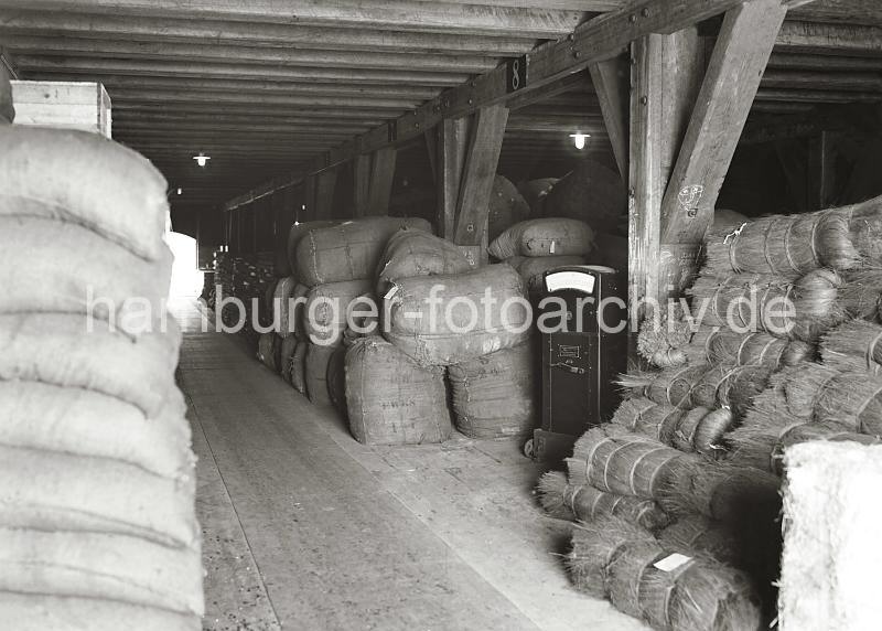 684_621 Lagerung von unterschiedlichen Gtern auf einem Boden eines Lagerhauses im Hamburger Freihafen. Rechts eine Waage der Fa. Dinse-Maschinenbau AG, die auf Rdern durch den Lagerraum bewegt werden kann. Warenlagerung in einem Speicher - Historische Motive aus dem Freihafen Hamburgs aus dem Fotoarchiv der HHLA. 