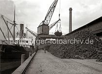 691_149 Die Krne am Hafenkai lschen eine Ladung Farbhlzern im Hamburger Hafen - in einem Netz hievt der Kran das Holz an Land und stapelt es auf dem Hafenkai. Ein Kaiarbeiter steht oben auf dem Holzberg und nimmt die Hieve in Empfang und ffnet das Netz.