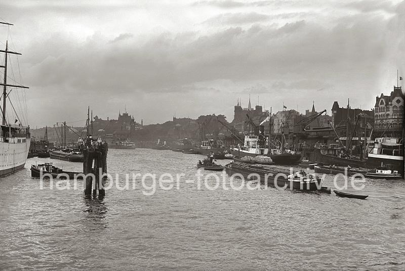 Bilder von Hamburg als Geschenk: Schiffe an den Vorsetzen - Rhein-Maas Kai mit Krnen - Huser.  714_B_229a Blick auf die Kaianlage der Rhein / Maas Binnenschifffahrt - kleinere Motorschiffe haben am Kai festgemacht; Schuten und Binnenschiffe liegen mit Fracht lngsseits. Hinter den Auslegern der Hafenkrne die Wohn- und Geschftshuser an den Vorsetzen sowie die der Kirchturm der Gustav Adolf Kirche und die Hamburger Seewarte auf dem Stintfang.