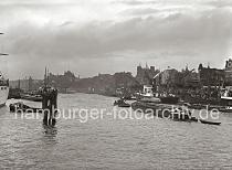 714_B_229a Blick auf die Kaianlage der Rhein / Maas Binnenschifffahrt - kleinere Motorschiffe haben am Kai festgemacht; Schuten und Binnenschiffe liegen mit Fracht lngsseits. Hinter den Auslegern der Hafenkrne die Wohn- und Geschftshuser an den Vorsetzen sowie die der Kirchturm der Gustav Adolf Kirche und die Hamburger Seewarte auf dem Stintfang.