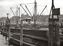 716_B_230 Zwei Schuten liegen an den Holzdalben beim Johannisbollwerk, die Schiffstaue sind so um die Holzpfhle gelegt, dass die Lastkhne sich mit der Tide bewegen knnen. Dahinter wird gerade eine Hieve Scke von einem Kstenmotorschiff auf ein Binnenschiff verladen.