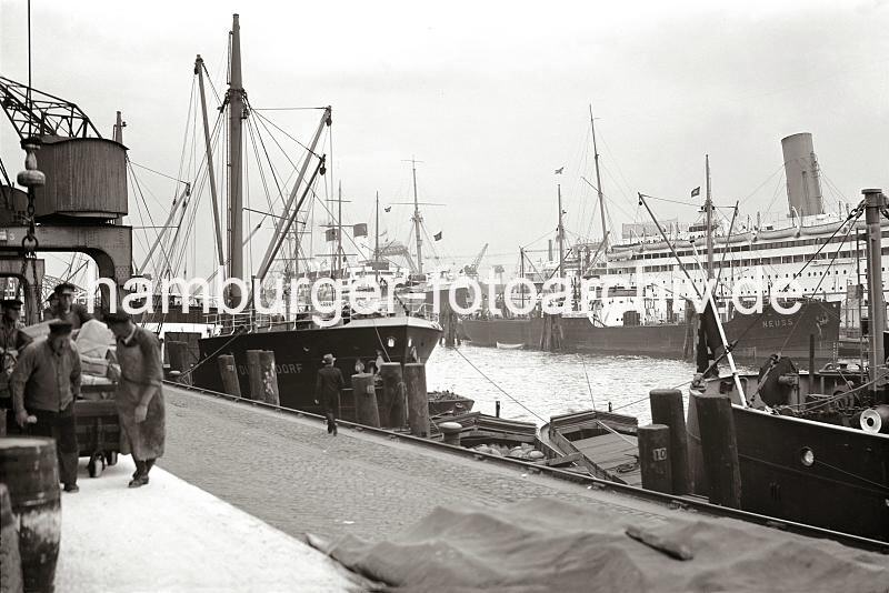 Hamburgbilder auf Leinwand als Geschenk fr die Firma + Buero + Jubilaeum : Kaiarbeiter auf dem Kai am Johannisbollwerk, Fracht- und Passagierschiffe. 718_B_230 Vier Kaiarbeiter ziehen eine mit Pckchen und Paketen beladene schwere Karre auf der Rampe auf dem Kai der Rhein-Maas Binnenschifffahrtslinien am Johannisbollwerk. Am Ponton der berseebrcke liegen die Passagierschiffe WILHELM GUSTLOFF und die MONTE OLIVIA der Hamburg Sd.