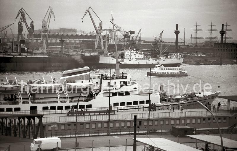 Bilder der Nachkriegszeit aus dem Archiv der Hamburger Hafen und Logistik AG. Fahrgastschiff WAPPEN VON HAMBURG an den St. Pauli Landungsbrcken, 1956. 721_5 Die 1955 gebaute WAPPEN VON HAMBURG liegt an den St. Pauli Landungsbrcken; das 17,5 Knoten schnelle Seebderschiff fuhr Tagesgste zu Deutschlands einziger Hochseeinsel Helgoland. Am gegenber liegenden Elbufer die Werft Blohm & Voss.