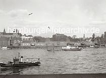 723_524 Blick ber die Elbe zu den St. Pauli Landungsbrcken - lks. das Kuppelgebude vom Eingang des Elbtunnels und re. hinter dem Pegelturm die Hochbahn-Haltestelle Landungsbrcken; dahinter das Gebude der Hamburger Seewarte. In der Bildmitte das 1864 gebaute Seemannsheim und lks. die Navigationsschule.