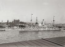 725_525a Blick von Hamburg Steinwerder auf die Elbe - ein Schiff verlsst den Hamburger Hafen mit Schlepperuntersttz- ung.  Dahinter das Panorama des Hamburger Elbufers beim Johannisbollwerk mit der Seewarte, Pegel- und Uhrturm, Bismarckdenkmal und dem Turm des Michels.