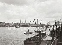 727_616 Der Passagierdampfer MONTE PASCOAL hat an der berseebrcke fest gemacht. Das 1930 gebauten Passagierschiff mit Heimathafen Hamburg konnte ca. 2400 Passagiere an Bord nehmen und hatte eine Besatzung von 336 Personen. Im Vordergrund schleppt der Schlepper AEGIR einen abgedeckten Elbkahn durch den Hafen.