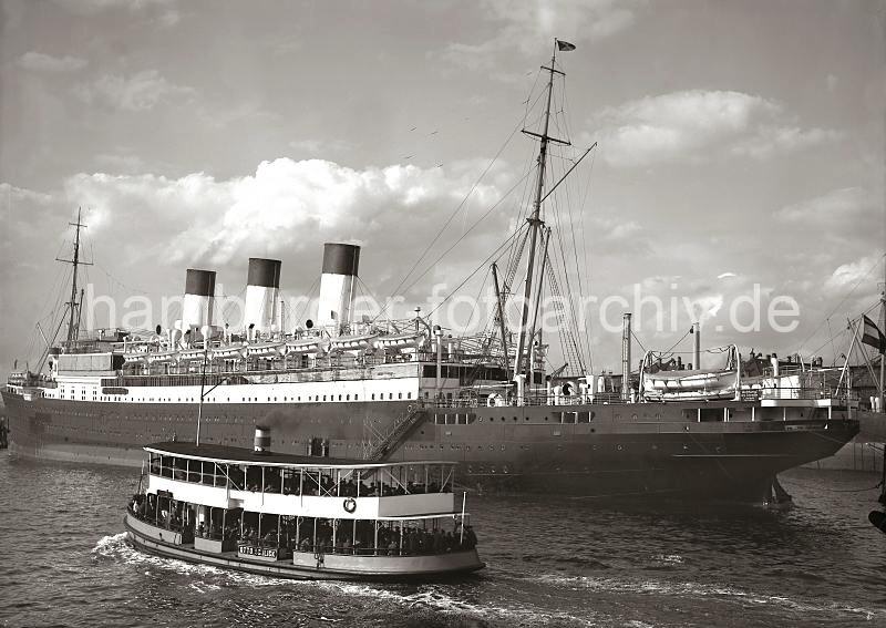 Historische Schiffsbilder - CAP POLONIO und Hafenfhre im Hamburger Hafen; ca.1938. 737_125 Der Passagierdampfer Cap Polonio der Hamburg Sdamerikanischen Dampfschifffahrts-Gesellschaft / Hamburg Sd hat im Strom fest gemacht. Das ca. 200m lange und 22m breite Passagierschiff konnte 356 I. Klasse-, 250 II. Klasse- und 950 Zwischendeckpassagiere an Bord nehmen - der 1914 bei Bohm & Voss gebaute Schiff hat eine Besatzung von 460 Personen.