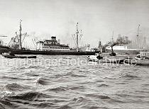 738_B_309 Der Frachter WALTRAUD HORN bei seinem Wendemanver auf der Elbe vor dem Strandhafen - zwei Hafenschlepper untersttzen das Seeschiff bei der Aktion. Barkassen und ein Schleppzug warten darauf, dass die Durchfahrt wieder frei ist. Im Hintergrund re. der Turm des Michels und der Uhrturm vom Kaispeicher A.