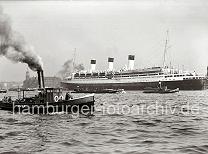 739_B_308a Der Passagierdampfer CAP ARCONA liegt vertut an den Dalben des Strandhafens; der Luxusdampfer lief 1927 vom Stapel. Das 196m lange Passagierschiff hat eine Breite von ca. 26m und konnte 850 Passagiere an Bord nehmen (1937). Im Vordergrund ein Hafenschlepper unter Dampft - dahinter das Gebude des Kaispeichers A am Kaiserhft.