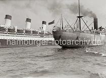 740_398 Das britische Frachtschiff PORT ADELAIDE mit Schlepperhilfe auf der Elbe - Qualm steigt aus dem Schornstein des Schiffs. Dahinter die drei markanten Schornsteine des Flaggschiffs der Hamburg Sdamerika Linie, das Passagierschiff CAP ARCONA.