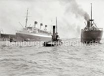 741_398a Das britische Frachtschiff PORT ADELAIDE mit Schlepperhilfe auf der Elbe - dicker Qualm steigt aus dem Schornstein des Schiffs. Der Passagierdampfer CAP ARCONA hat im Strom festgemacht und ist an den Dalben des Strandhafens vertut. Im Hintergrund die Brckenbogen der Hamburger Elbbrcken.