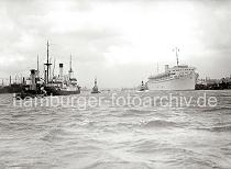 745_363a Ein Motorschiff luft aus dem Hamburger Hafen aus. Mit Hilfe von Hafenschleppern fhrt das Frachtschiff im Strom der Elbe in Hhe der berseebrcke. Rechts liegt das Kreuzfahrtschiff Wilhelm Gustloff am Ponton - das 1938 fertig gestellte  Passagierschiff kann 1 463 Passagiere an Bord nehmen. Der Passagier-Dampfer wurde von der national- sozialistischen Organisation "Kraft durch Freude Kdf" als Kreuzfahrtschiff genutzt.