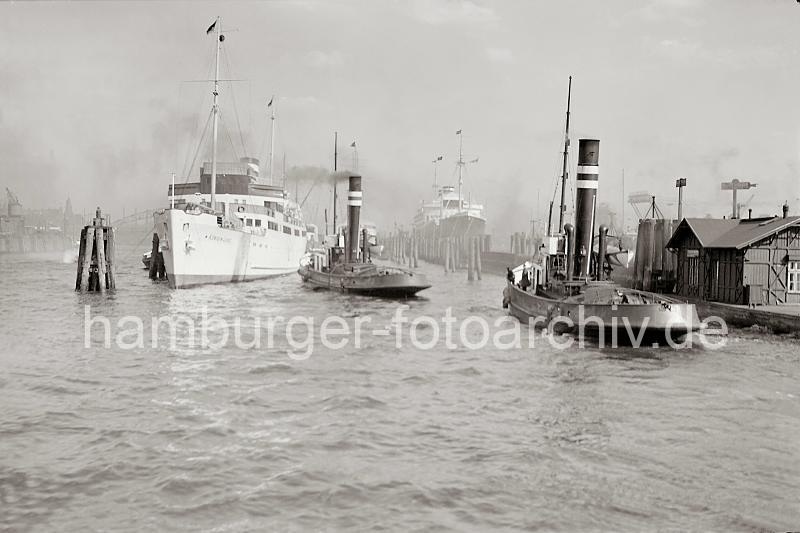 Alte Hafenbilder aus Hamburg - Schiffe im Hamburger Hafen - Seebderschiff KNIGIN LUISE - Schlepper an den Vorsetzen; ca.1938.  746_400 Das Motorschiff KNIGIN LUISE hat an ihrem Liegplatz an den Dalben bei den Vorsetzen festgemacht. Das Fahrgastschiff hat eine Lnge von 86m und eine Breite von 13m - ca. 2000 Personen knnen auf der Seebder-Route Hamburg-Cuxhaven-Helgoland-Sylt an Bord genommen werden.