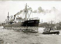 748_B_280b Der Frachter BARMBEK der Reederei Knhr & Burchard verlsst den Hamburger Hafen - er fhrt ohne Schlepperhilfe auf der Elbe flussabwrts, eine Barkasse fhrt vor dem Bug des Schiffs. Im Hintergrund hat das Frachtschiff LEONIAN in der Reiherwerft eingedockt.