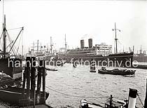 750_B_278 Die RMS VICEROY OF INDIA der Reederei Peninsular and Oriental Steam Navigation Company (P&O) liegt am Ponton im Hamburger Hafen bei den Landungsbrcken. Am Kai der Rheinschifffahrt wird gerade in der Schute eine Hieve Fsser zur Anlandung vorbereitet, dahinter das Motorschiff NEUSS mit seinen Ladebumen.