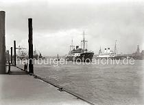 755_763 Das russische Motorschiff SMOLNY luft mit Schlepperbegeleitung in den Hamburger Hafen ein. Im Hintergrund hat die MONTE PASCOAL im Strom festgemacht. Rechts ragt der Turm der St. Michaeliskirche hinter den Dchern der Kaischuppen und Speicherstadt-Lagerhusern empor. Das Hamburger Wahrzeichen ist eine der fnf Hauptkirchen der Hansestadt und hat eine Hhe von 132m.