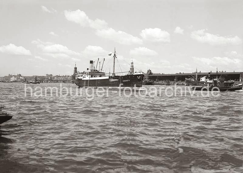 Historische Hafenbilder aus Hamburg Schiffe auf der Elbe - Kaischuppen am Hamburger Strandhafen ca.1936.  756_2_613 Der Frachter MARGARETA luft geschleppt von dem Schlepper STOCKHOLM in den Hamburger Hafen ein - dahinter fhrt ein Schleppverband auf dem breiten Hamburger Fluss.  Am Strandkai liegen Motorschiffe und Lastkhne - im Hintergrund sind die berseebrcke und die dort liegenden Hafenschlepper zu erkennen.