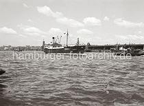 756_2_613 Der Frachter MARGARETA luft geschleppt von dem Schlepper STOCKHOLM in den Hamburger Hafen ein - dahinter fhrt ein Schleppverband auf dem breiten Hamburger Fluss.  Am Strandkai liegen Motorschiffe und Lastkhne - im Hintergrund sind die berseebrcke und die dort liegenden Hafenschlepper zu erkennen.