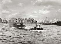 756_B_277 Aus dem Schornstein des Hafenschleppers SPREEHAFEN steigt dichter Qualm - das Arbeitsschiff schleppt das Binnenschiff SEYDLITZ  ber die Elbe. Im Hintergrund das Hamburger Panorama mit dem Turm des Michels, dem Kuppelgebude des Elbtunnel, dem Seemannsheim und der Seewarte auf dem Stintfang.