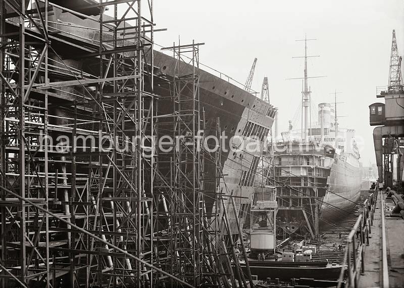 Schwimmdock der Hamburger Werft Blohm & Voss; ca.1934. 762_632a HAPAG Passagierschiffe der Ballin-Klasse liegen fr Umbauarbeiten im Schwimmdock der Traditionswerft Blohm & Voss. Ein Schwimmdock ist eine schwimmende, tauchfhige Vorrichtung zur Aufnahme und Anhebung von Schiffen. Soll ein Schiff das Dock belegen, werden die Fluttanks der Docks geflutet - nachdem das einzudockende Schiff im Schwimmdock positioniert wurde, werden die Ballasttanks leergepumpt und das Dock mitsamt dem Schiff hebt sich an. Ein Trockendock ist eine Art Hafenbecken, in der das einzudockende Schiff einfhrt. Danach wird das Dock leergepumpt und das Schiff liegt auf dem Trockenen - mit Hilfe von Sttzen / Pallen wird der Schiffskrper fest in Position gehalten.