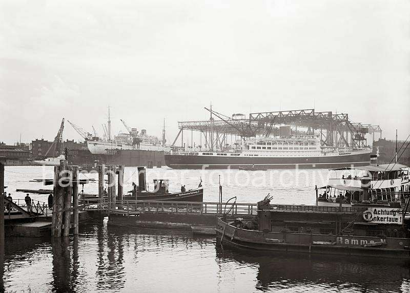 Historische Hamburg Fotografien als Geschenk zum Jubilaeum - Passagierschiff POTSDAM - Werft BLOHM & VOSS; 1935 764_764a Blick von den Pontons der St. Pauli Landungsbrcken zum Werftgelnde der Schiffswerft BLOHM & VOSS. Der auf der Hamburger Traditionswerft gebaute 193,2m  lange und 22,6m Schnelldampfer POTSDAM ist fertig gestellt und liegt zur bergabe bereit; daneben die eingedockte MILWAUKEE. Im Vordergrund liegt ein Arbeitschiff und die  Barkasse der Hafenunterhaltung 3 am Anleger.