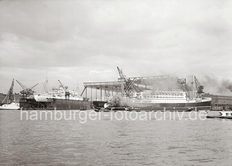 765_764 Der fertig ausgerstete Schnelldampfer POTSDAM liegt zur bergabe vor der Werft BLOHM & VOSS; ein Schleppverband passiert gerade die Werft - dicker Qualm steigt aus dem Schornstein des Hafenschleppers ZAR II.  Im Schwimmdock liegt die 1929 auch auf Blohm & Voss gebaute Kreuzfahrtschiff MILWAUKEE. Historische Hamburg Bilder als Geschenk zum Firmenjubilaeum - Schnelldampfer POTSDAM - Passgierschiff MILWAUKEE - Werft BLOHM & VOSS; 1935. 