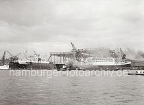 765_764 Der fertig ausgerstete Schnelldampfer POTSDAM liegt zur bergabe vor der Werft BLOHM & VOSS; ein Schleppverband passiert gerade die Werft - dicker Qualm steigt aus dem Schornstein des Hafenschleppers ZAR II.  Im Schwimmdock liegt das 1929 auch auf Blohm & Voss gebaute Kreuzfahrtschiff MILWAUKEE.