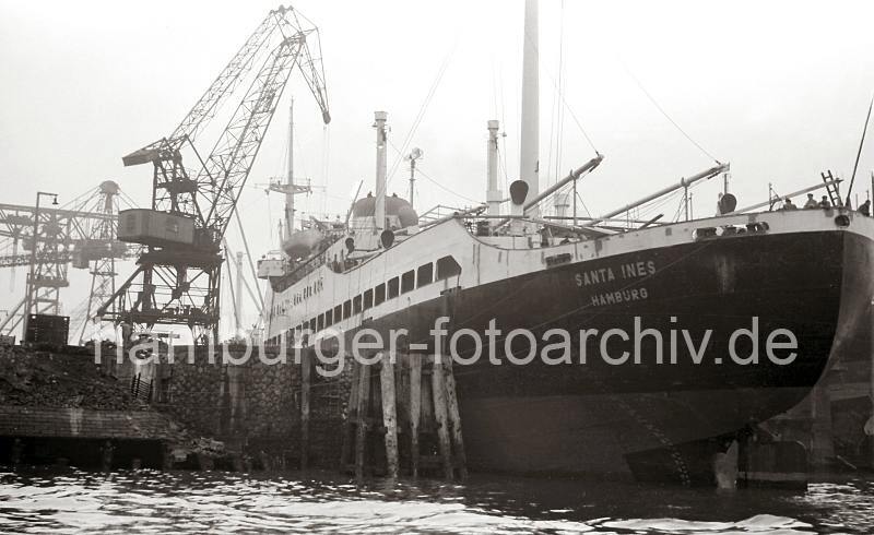 767_1 Das neugebaute Kombischiff SANTA INS der Reederei HAMBURG SD liegt am Ausrstungskai der Hamburger HOWALDSWERKE AG. Das Motorschiff hat eine Lnge von 146m und eine Breite von 18,70m. Historische Hamburg Bilder als Geschenk fuer Weihnachten - Fracht- und Passagierschiff SANTA INS - HOWALDSWERKE HAMBURG AG; 1953. 