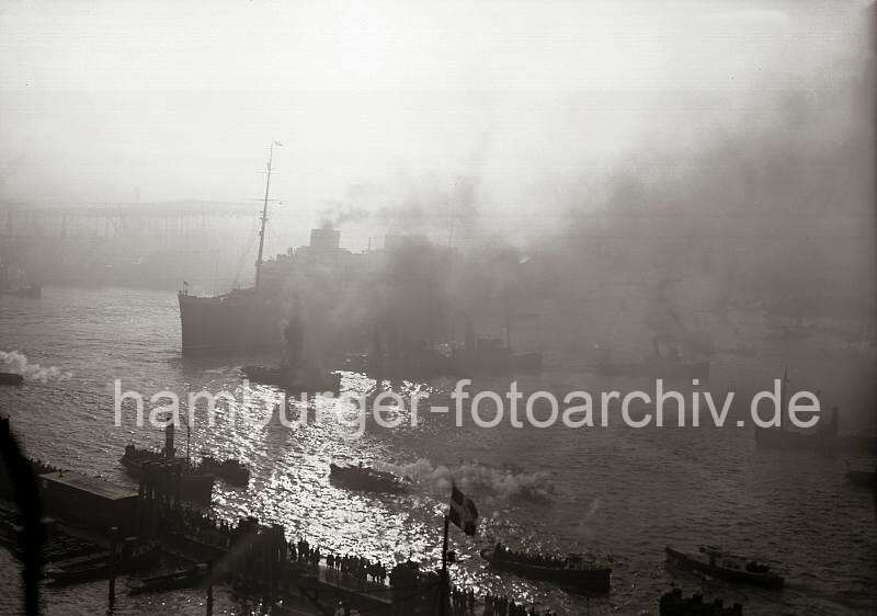 Gegenlichtaufnahme Hafen Hamburg - Schlepper, Qualm - Passagierschiff EUROPA; ca. 1930. historische Hamburgfotos Druck als Weihnachtsgeschenk, Geburtstagsgeschenk, Jubilaeum. 773_195 Das Passagierschiff EUROPA im Hamburger Hafen - eine Parade von Schleppern und Barkassen begleiten desn Schnelldampfer bei seiner Ausfahrt aus Hamburg. Dicker Qualm steigt aus den Schloten der Schiffe - Schaulustige stehen im Abendlicht auf den Pontons und beobachten das Schauspiel.