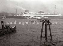 777_197 Der Passagierdampfer EUROPA wird von den Schleppern in das Fahrwasser der Elbe gezogen, damit das Schiff seine Fahrt in seinen Heimathafen Bremen antreten kann. Von dort soll die Jungfernfahrt ber den Atlantik nach New York starten. Barkassen und andere Kleinschiffe begleiten den Luxusdampfer beim Auslaufen aus dem Hamburger Hafen.