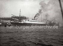 780_199 Die EUROPA verlsst mit qualmenden Schornstein den Kai der Werft Blohm & Voss und startet seine Fahrt nach Bremerhaven um von dort die Jungfernfahrt nach New York zu unternehmen. Auf dem oberen Deck zwischen den beiden Schornsteinen befindet sich ein Katapult mit einem Schwimmflugzeug. Das Flugzeug diente der schnelleren Postbefrderung; es wurde 800 bis 1000 km vor dem Zielhafen von Bord gestartet.