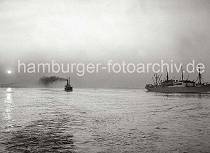 786_B_235 Zwei Frachtschiffe fahren in der Abenddämmerung auf der Elbe Richtung Hamburger Hafen - die Abendsonne spiegelt sich im Wasser des Flusses, dicker Qualm steigt aus einem Schiffsschornstein.