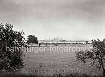 787_B_234a Eine Herde Pferde grasen auf den Wiesen am Elbufer - ein Turbinenpassagierschiff des Deutschen Afrika Dienstes fhrt auf der Elbe Richtung Nordsee. Die 1936 auf der Hamburger Werft Blohm % Voss gebauten kombinierten Passgier- und Frachtschiff WINDHUK und PRETORIA bedienen vom Heimathafen Hamburg aus die Deutschen Afrika-Kolonien.