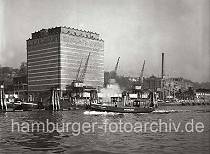 793_168 Das UNION KÜHLHAUS in Hamburg-Neumühlen; vor dem 1926 errichteten Gebäude stehen Kräne am Kai.  Eine Barkasse der Hafenpolizei fährt entlang der Duckdalben, die im Strom stehen.