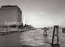 795_B_223a Hafenanlagen beim Khlhaus Neumhlen - Schuten liegen an der Kaimauer; im Hintergrund die hohen Portale der Kabelkrne und Helligen der Hamburger Werften an der Elbe. 