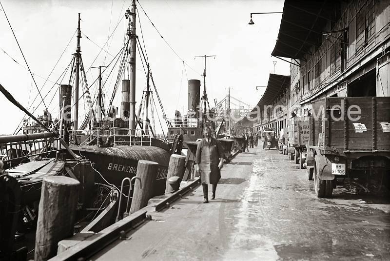 historische Fotos Altona - Fischfangschiffe im Hafen Altonas - Lastkraftwagen mit Ladeflche, Fischkisten; ca. 1937. AltonaMotive als Kunstdruck auf Leinwand + Poster.  805_B_287a Fischdampfer liegen am Kai des Fischereihafens Altona - vor den Hafenschuppen stehen LKW, auf der Ladeflche sind Fischkisten gestapelt. Ein Kleinlaster mit drei Rdern, eine Art Motorrad mit einer vorderen Ladeflche transportiert Kisten ber den Kai. Im Hintergrund sind die Krananlagen des Altonaer Kohlehafens zu erkennen.