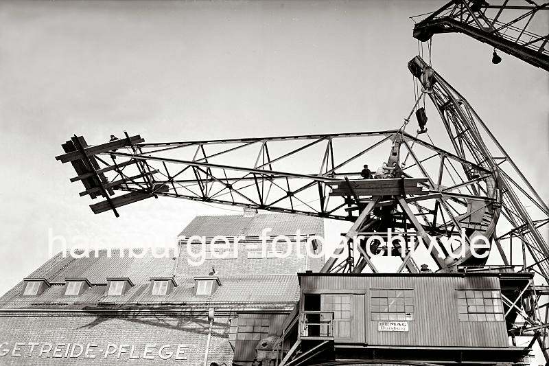 Alte Bilder Altonas - Demontage eines Schwerlastkrans - Abbau des Kranauslegers; 1938. Altonaer Bilder auf FotoleinwandLeinwand + als Fotoposter. 812_1_352a Arbeiter demontieren den Ausleger des 40 Tonnen DEMAG Krans im Altonaer Hafen. Die Arbeitskrfte stehen auf einer provisorischen Holzplattform und lsen mit einem groen Schraubschlssel eine Verbindung. Der Kranausleger wird durch den am Kai liegenden Schwimmkran gesichert.